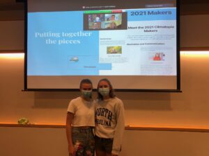 2 female Students standing in front of projector screen