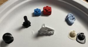 Different 3d printed game pieces set on a white surface