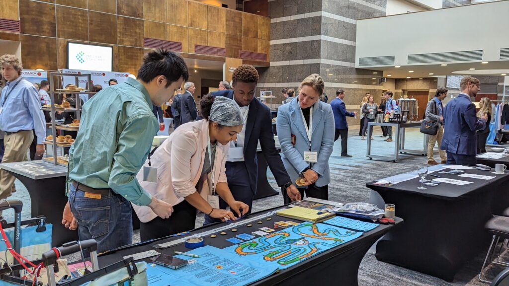 3 Climatopia students showing a woman the gameplay of Climatopia