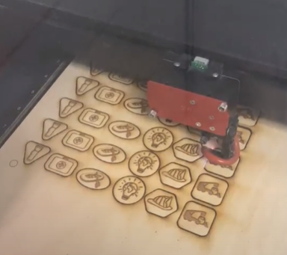 Laser wood cutter engraving many game pieces onto a slab of wood