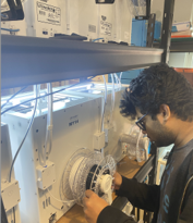 Pranav adjusting the settings of a 3D printer