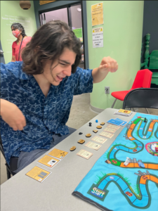 Student celebrates while playing climatopia with game in front of him