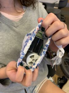 Student showing sewing kit that is held inside a bag