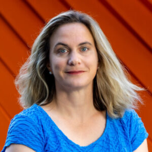 Headshot of Megan Mendenhall with an orange background