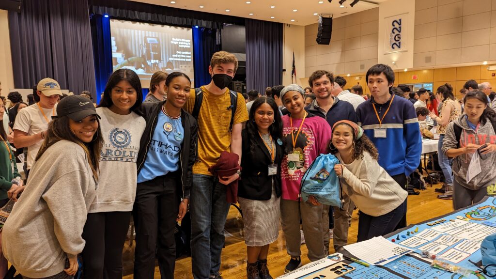 Group of Climatopia makers standing with arms around eachother with one holding a Climatopia game bag.