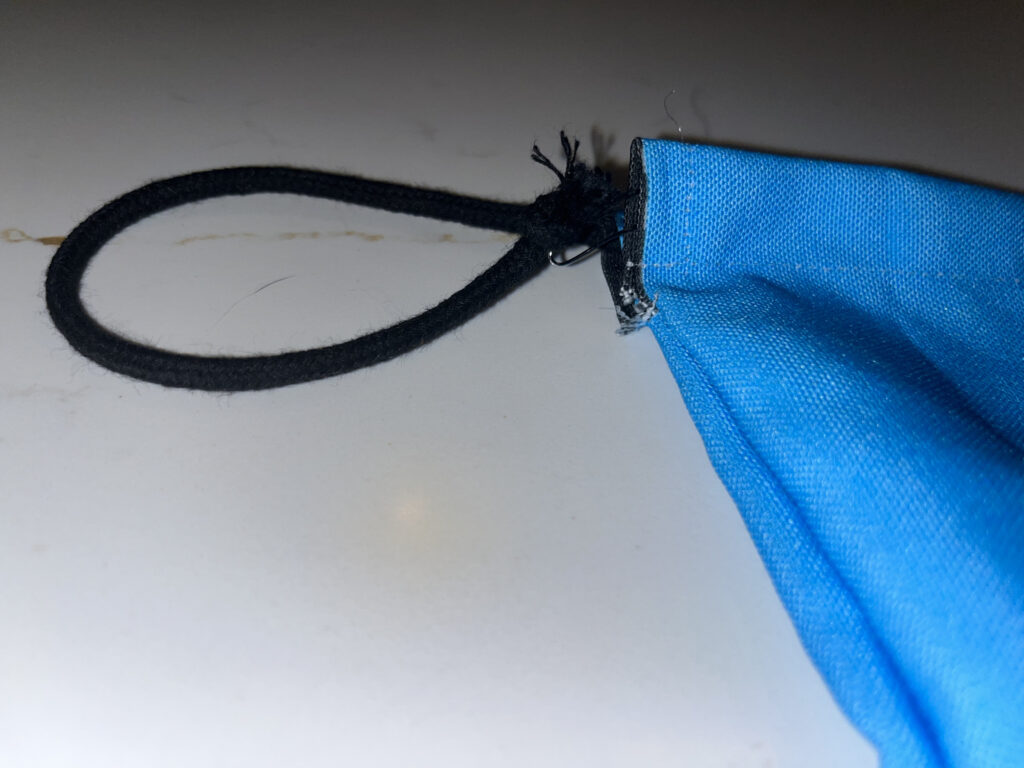 Black cord in a loop coming out of top of Climatopia drawstring bag