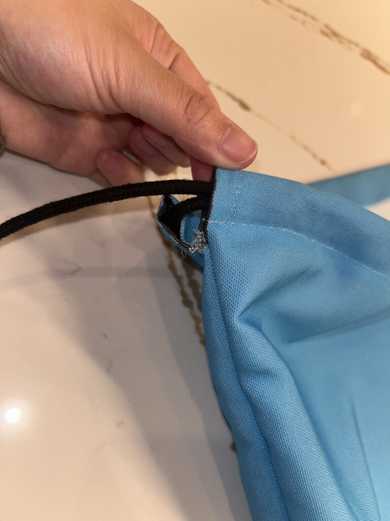 Black cord coming out of the top of carolina blue Climatopia bag