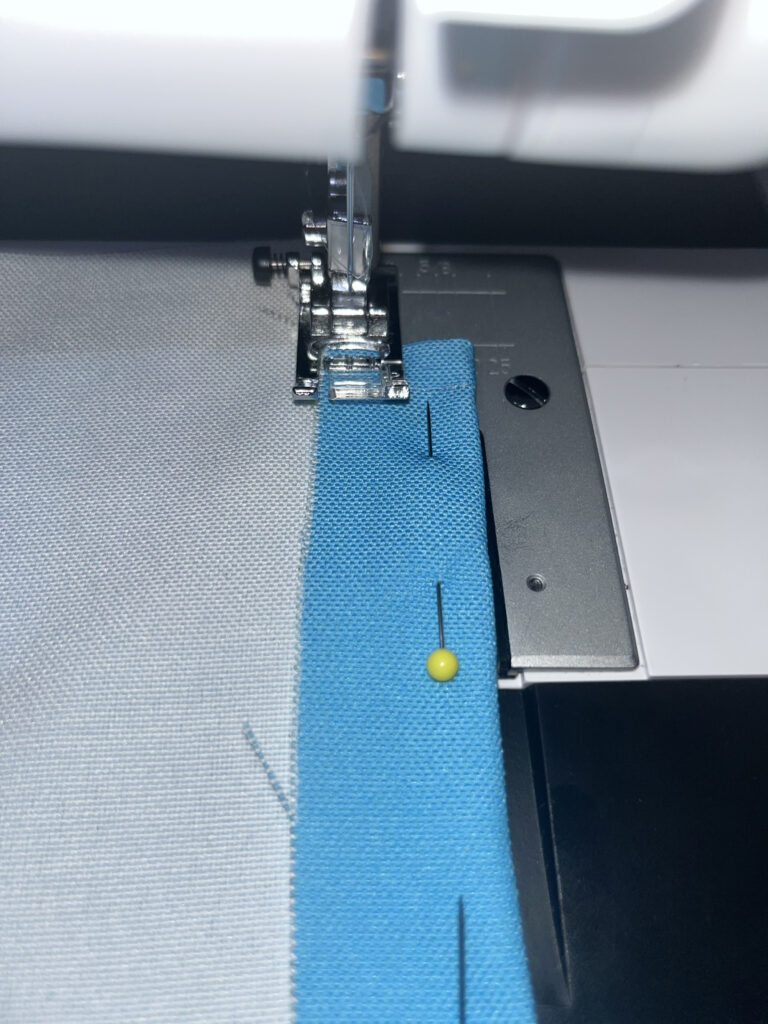 Fabric with a yellow pin in a sewing machine
