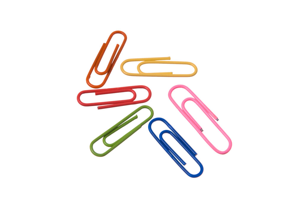 Different colored paper clips laying down