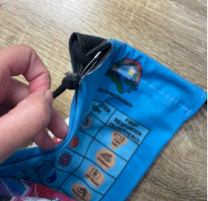 Bobby pin on the corner of the game piece bag connecting the black cord and the bag