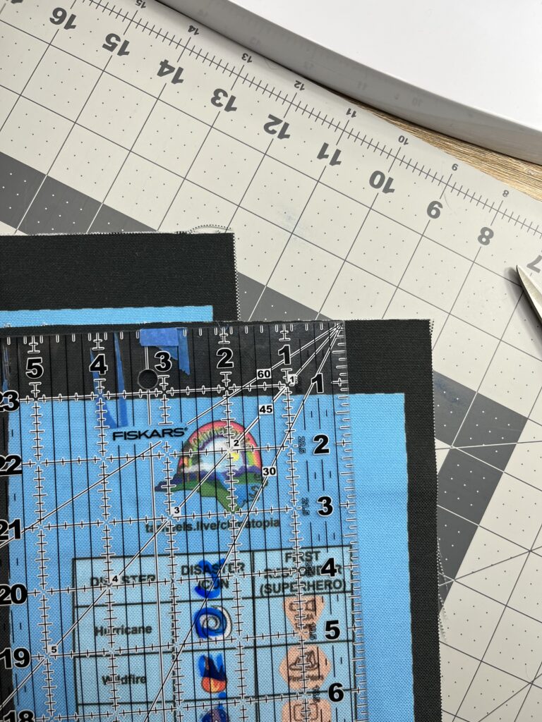Clear ruler laying on top of a Climatopia game piece bag fabric