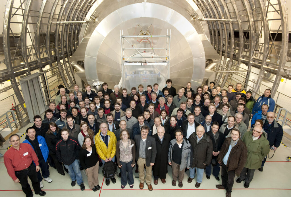 The members of KATRIN standing in front of the KATRIN experiment facility.