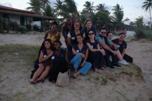 Members of the research group and Condo residents smile and pose on the beach