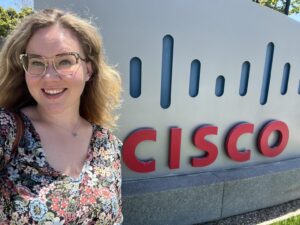 Courtney stands with the Cisco sign.